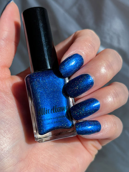 Ocean of Memories royal blue holographic nail polish painted on nails holding bottle