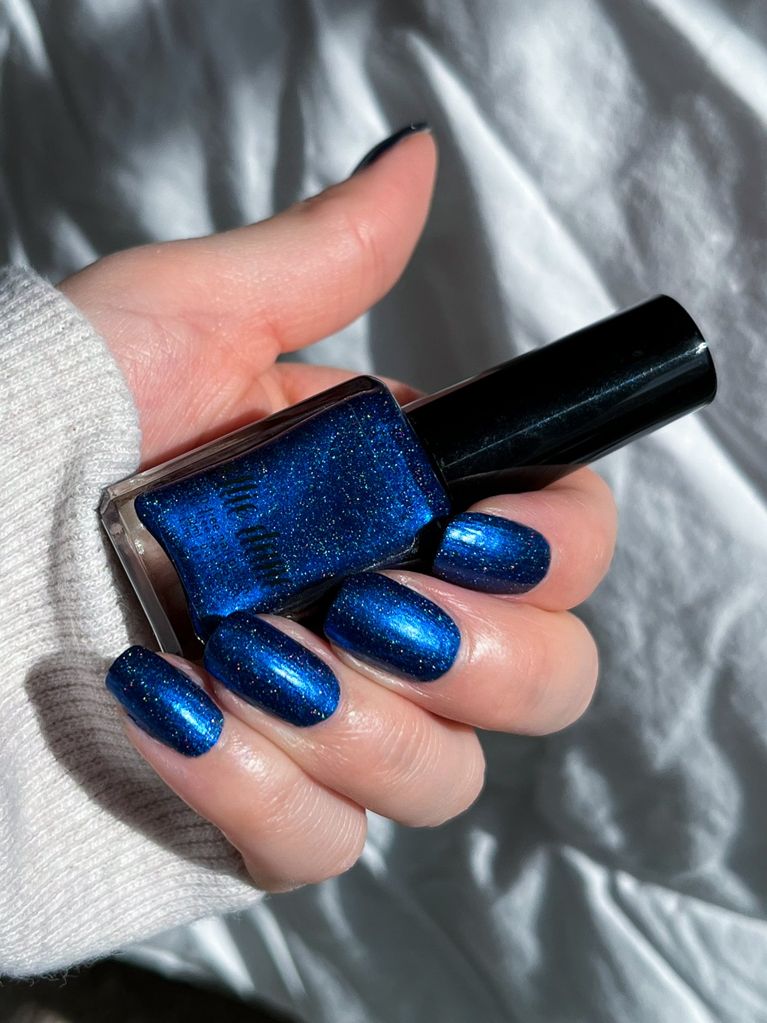 Ocean of Memories nail polish swatched on nails holding bottle in sunlight